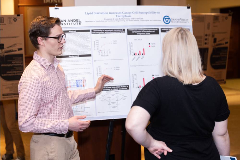 Cameron presenting to a guest at the 2023 Graduate Showcase.
